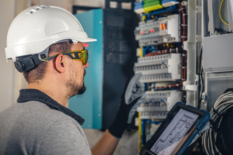 un électricien contrôle un tableau électrique pour illustrer nos produits